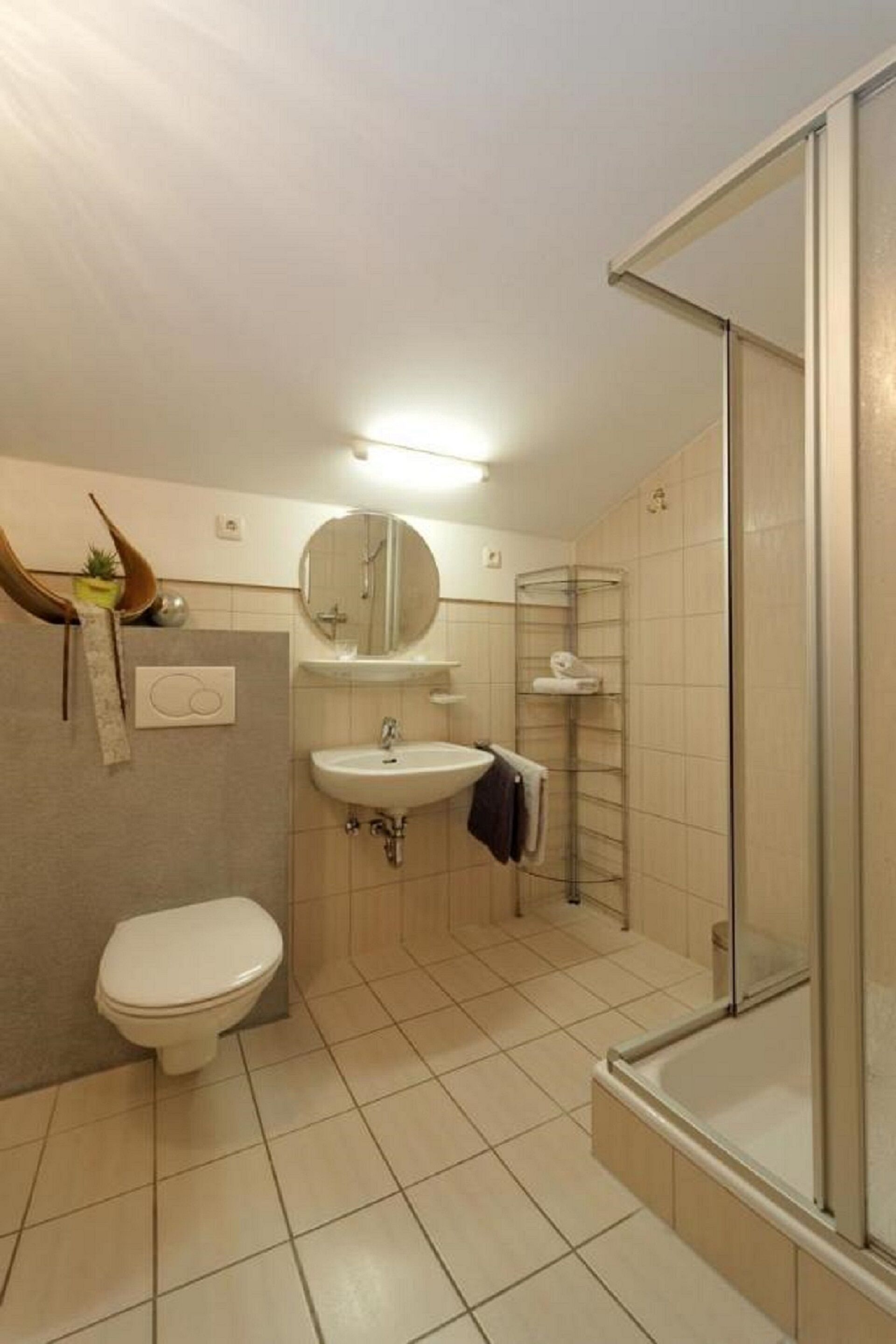 Ein modernes Badezimmer mit Toilette, Waschbecken und einer Duschkabine.