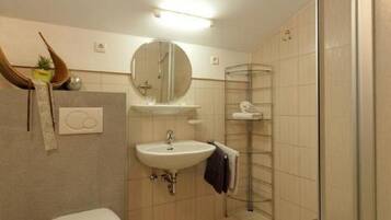 Ein modernes Badezimmer mit Toilette, Waschbecken und einer Duschkabine.