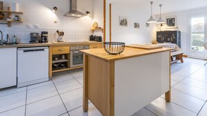 A modern kitchen with white cabinetry, a wooden island, and pendant lighting. - Spacious Ground-Level Home with Large Yard, Terrace, WiFi, and Game Amenities in Malville (Malville)