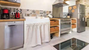 Une cuisine moderne équipée d’un lave-vaisselle, d’une machine à café, d’une cuisinière et d’un réfrigérateur.