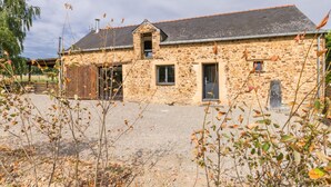 Un bâtiment en pierre doté d’un toit en pente et d’une petite structure adjacente.
