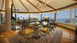A dining area with a table and chairs, a chandelier, and large windows with a view. - Luxury Villa Bahía with Infinity Pool, Panorama View, Sauna & Fitness Area (El Sauzal)