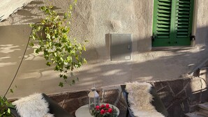 A small outdoor seating area with two chairs, a table, a lantern, and a green door. - Holiday Apartment "Casa di Ada" with Mountain Views and Wi-Fi (Segonzano)