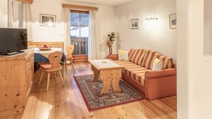 Een gezellige woonkamer met een bank, een eettafel en een televisie.