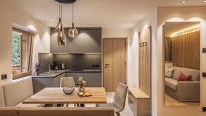 Una cuina moderna amb zona de dinar, detalls de fusta i vista cap a un saló.