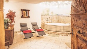Une salle de bain avec deux chaises longues, une baignoire et un meuble en bois.