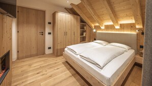 Une chambre à coucher avec un plafond en bois, un lit, une armoire et une table de chevet.