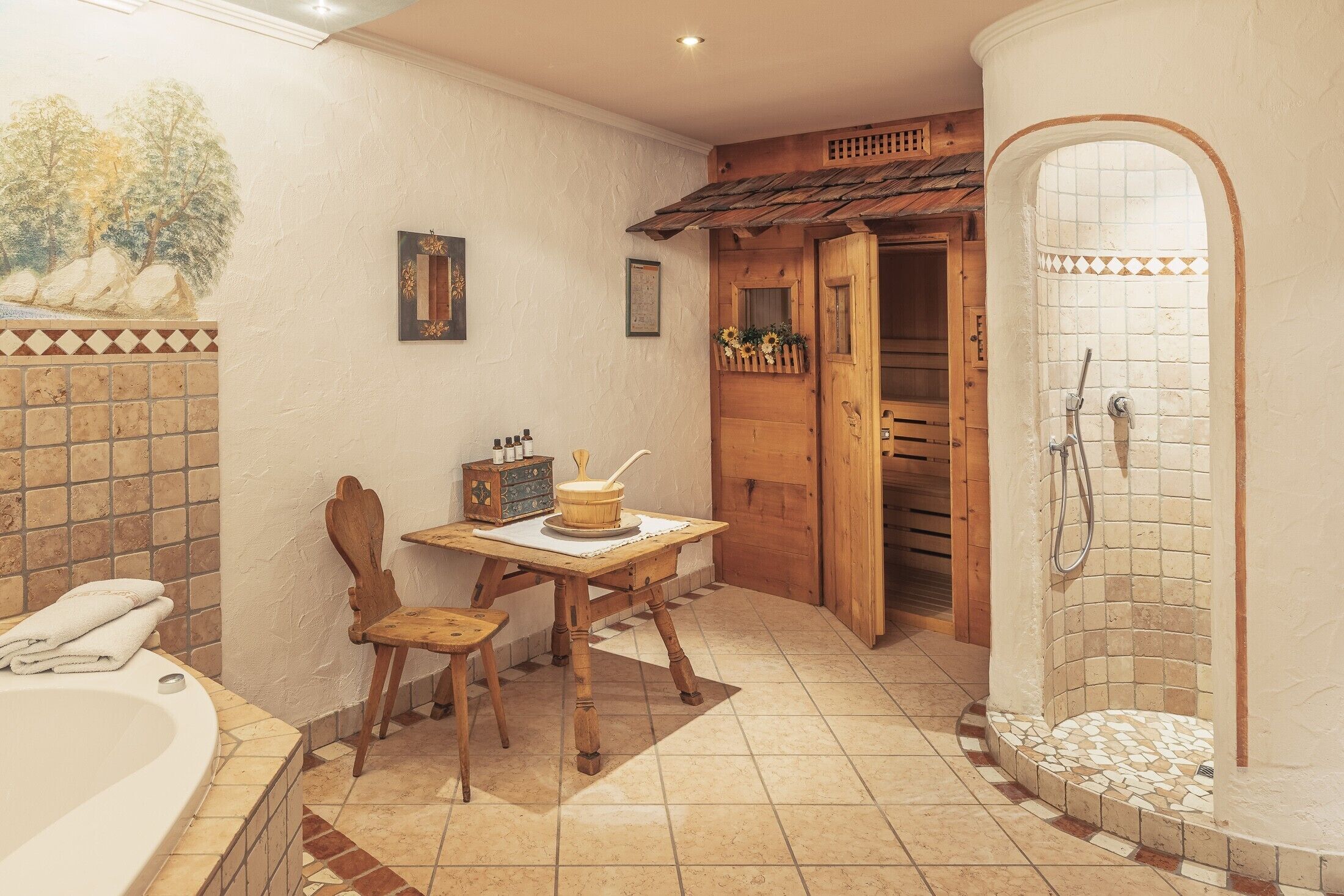 Une salle de bain avec une baignoire, une table en bois, une chaise, une douche et des murs carrelés.