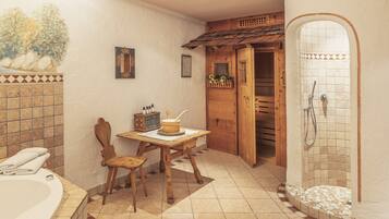Une salle de bain avec une baignoire, une table en bois, une chaise, une douche et des murs carrelés.