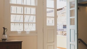 A room with a wooden dresser, a white door with glass panels, and a hanging light fixture. - Home with Terrace in Heart of old Town of Chania (Chania)