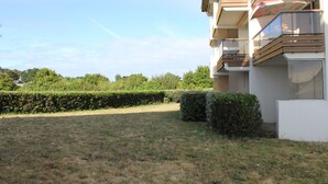 A residential building with multiple balconies, a well-maintained lawn, and a hedge. - DES AILES - Apartment Port Haliguen - parking - 1bedroom (Quiberon)