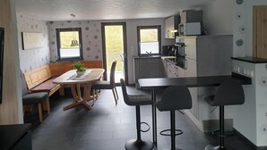 Cocina compacta con comedor, una barra pequeña y un balcón con vistas.