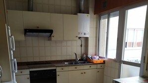 Una cocina con lavavajillas, pileta y ventana.
