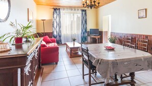 A dining area with a table, chairs, and a chandelier. - Countryside Cottage with Private Terrace and Garden, Near Châteaubriant (Grand-Auverné)