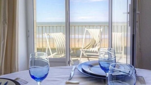 A table set for two with a view of the beach through a large window. - Cottage in Tharon: 2 bedrooms, terrace, parking, near the sea (Saint-Michel-Chef-Chef)