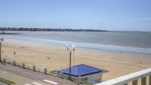 A beach view with a small building, a clear sky, and a distant shoreline. - Cottage in Tharon: 2 bedrooms, terrace, parking, near the sea (Saint-Michel-Chef-Chef)