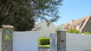 A gated rural property with a stone wall and a white gate. - Charming Cottage with Fireplace, Mezzanine, and Garden near Guérande (Saint-Molf)