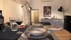 A dining table with a bottle of wine, glasses, and plates of food.