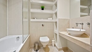 Une salle de bain moderne avec une baignoire, des toilettes et un lavabo.