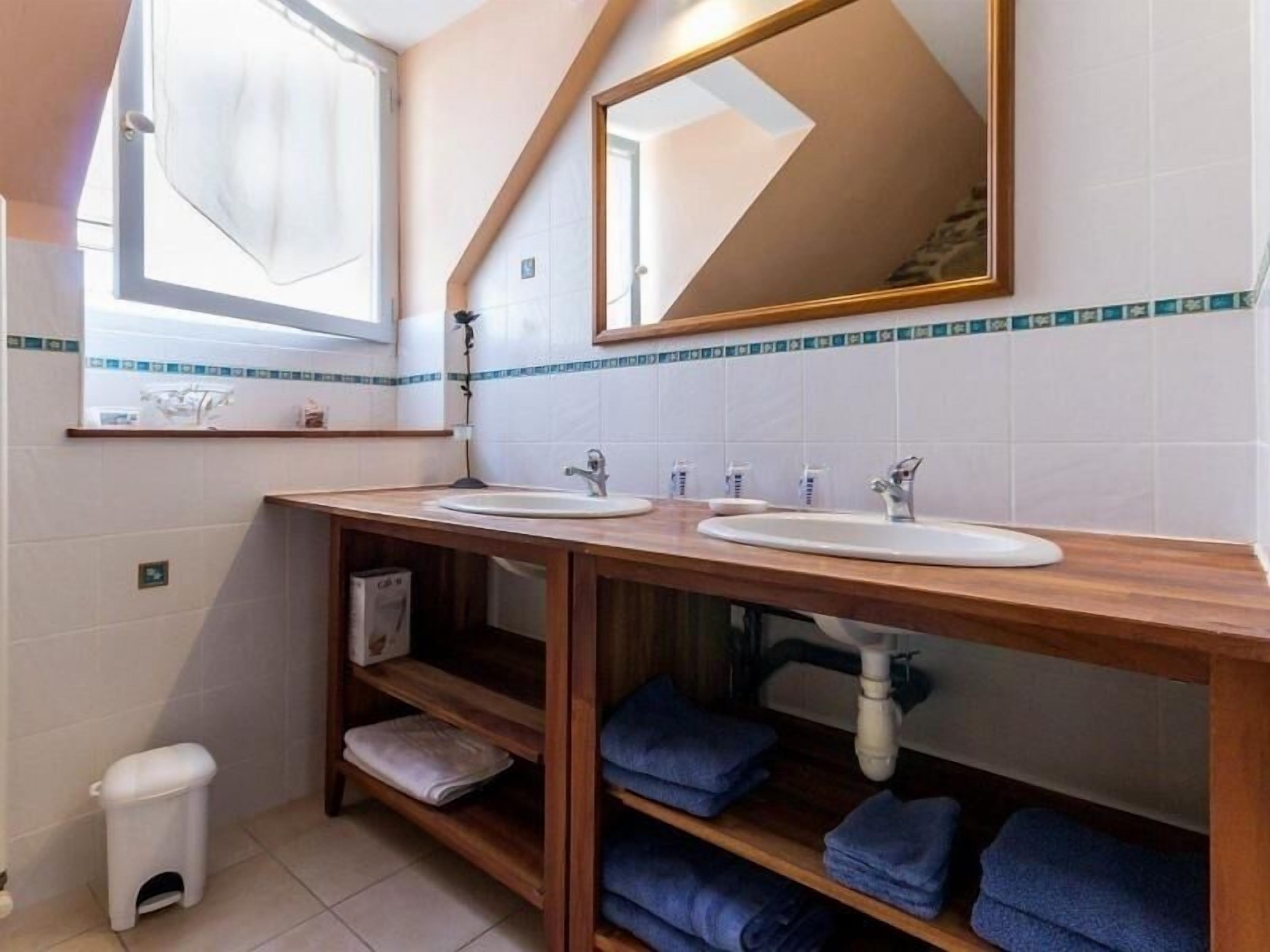Een badkamer met twee wasbakken, een spiegel en een handdoekhouder.