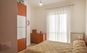 Relax in this serene bedroom with a comfortable bed, dresser, and radiator, set against a neutral backdrop.