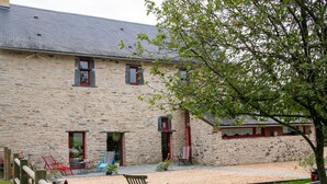 A stone building with a sandy courtyard, wooden fence, and a tree. - Spacious Country House with Private Pool and Enclosed Garden (Pannecé)