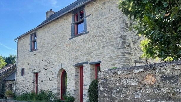 A stone building with red-framed windows and a stone wall. - Spacious Country House with Private Pool and Enclosed Garden (Pannecé)