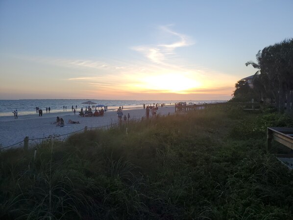 A beach scene with people relaxing and walking along the shore.