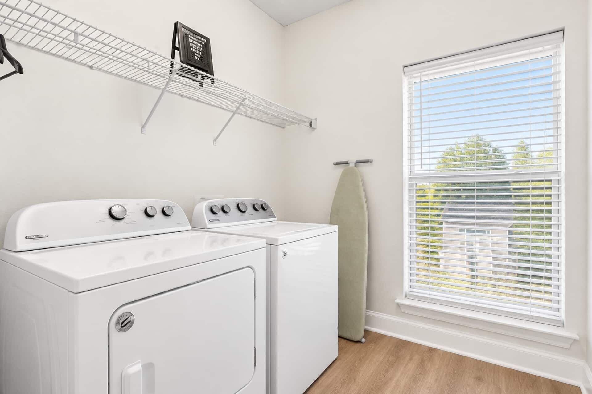 Une buanderie équipée d’un sèche-linge, d’une machine à laver et d’un étendoir à linge.