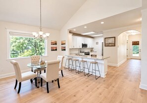 Bright open dining area with breakfast bar, vaulted ceilings, and garden views - Bayou Waterfront Cottage with Backyard Fishing (Biloxi)