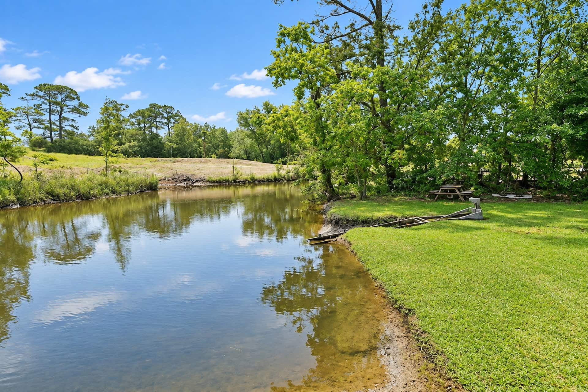 Peaceful waterfront lawn with shaded picnic spot and scenic views