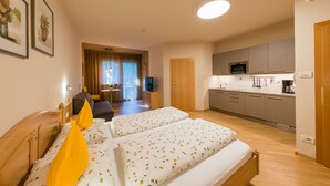 Une chambre d’hôtel équipée d’un lit, d’une télévision, d’une kitchenette et d’un coin repas avec vue.