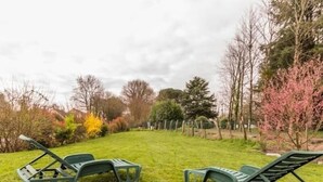 Two green lawn chairs in a grassy area with trees and shrubs in the background. - Modern House with Garden, Near Nantes - 3 Bedrooms, Wifi, Baby Equipment, Enclosed Garden (Nozay)