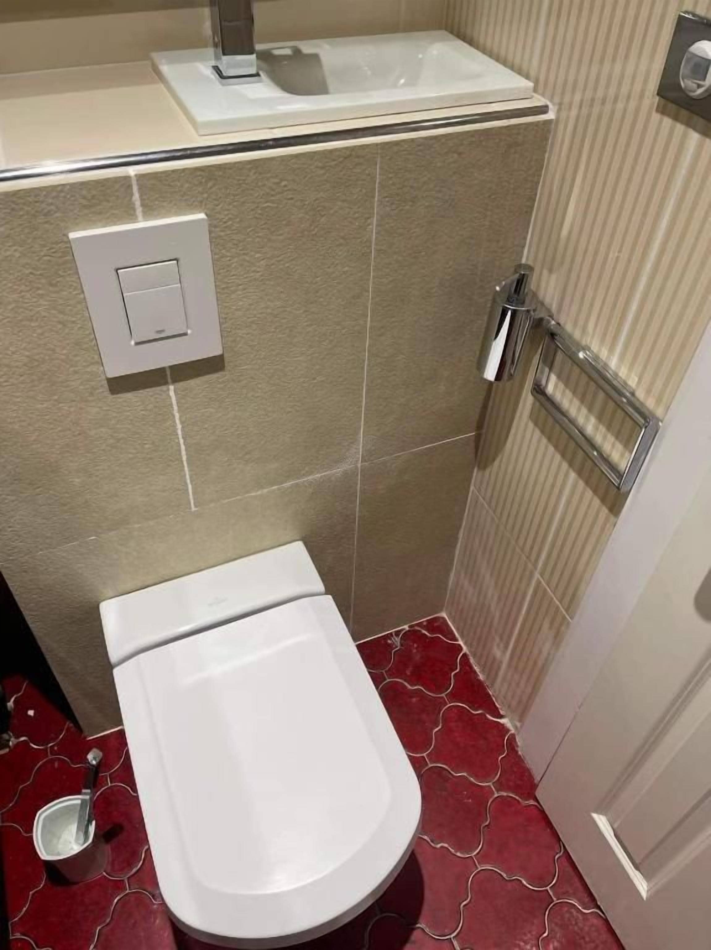 A small bathroom with a toilet, a sink, and a shower.