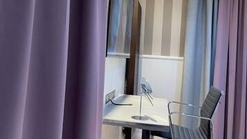 Een moderne kantoorruimte met een bureau, stoel en grote spiegel.