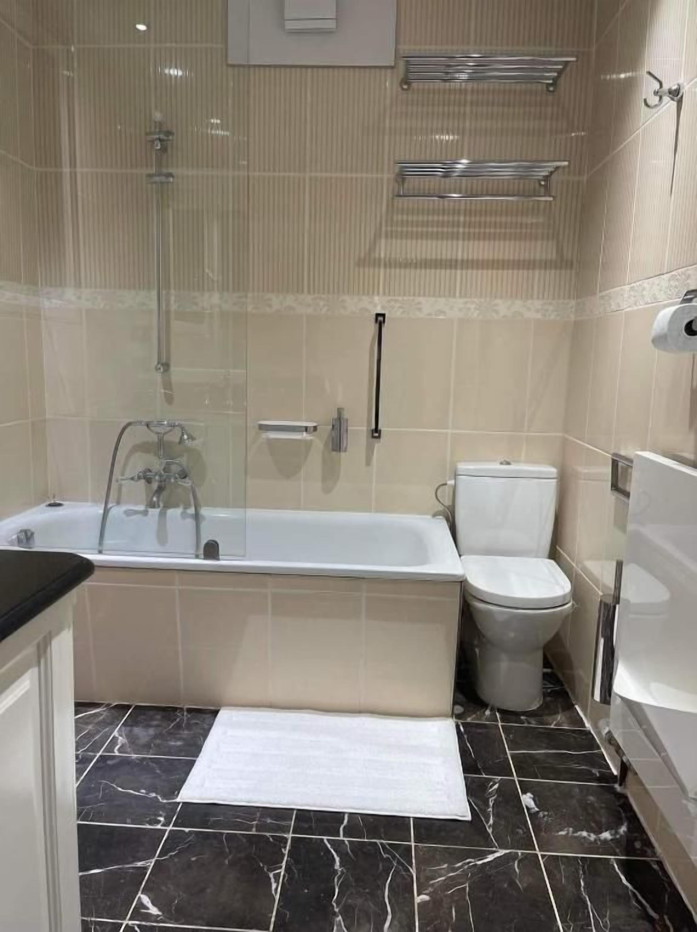 Un baño con bañera, inodoro y ducha.