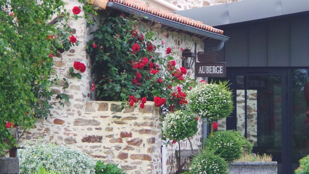 Un bâtiment en pierre sur lequel on peut lire l’inscription « AUBERGE ».