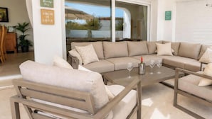 A modern living room with a beige sofa, a wooden coffee table, and a glass of wine. - Colina - modern 3 bedroom villa close to town/beaches (Moraira)