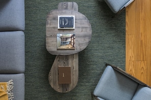Una sala moderna con una mesa de centro de madera, dos libros y una caja marrón pequeña.
