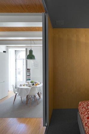 A modern room with a bed, a dining area with a table and chairs, and a bookshelf. - Flattered to be in Porto City View Apartment B (Oporto)