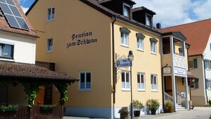 A yellow building with the sign "Pension zum Schwan" indicating a hotel. - Pension Zum Schwan (Muhr am See)