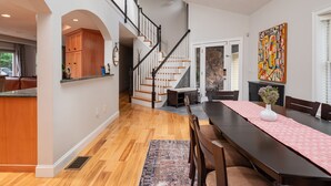 A spacious dining area with a long table, wooden chairs, and a decorative vase.