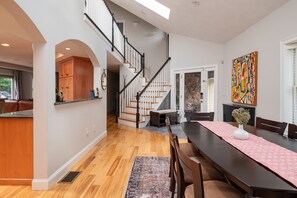 Enjoy a homey atmosphere in this inviting space with a dining area, kitchen, and staircase leading to additional living space.