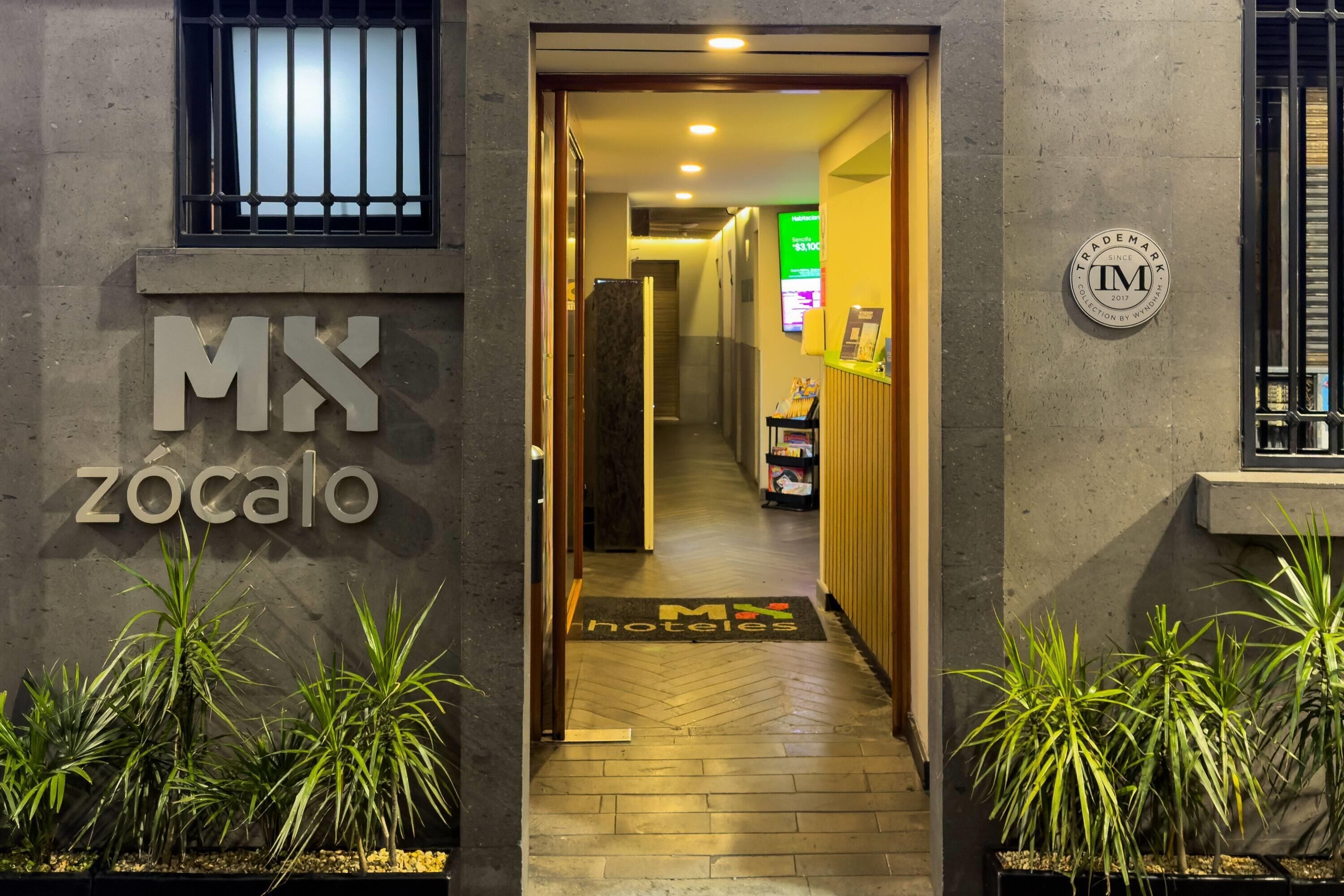 Een hotelentree met een bord waarop 'MX Zócalo' staat en een 'TradeMark' logo.