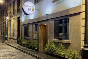 A hotel facade with a sign reading 'hoteles MX' and a logo with a house and a heart.
