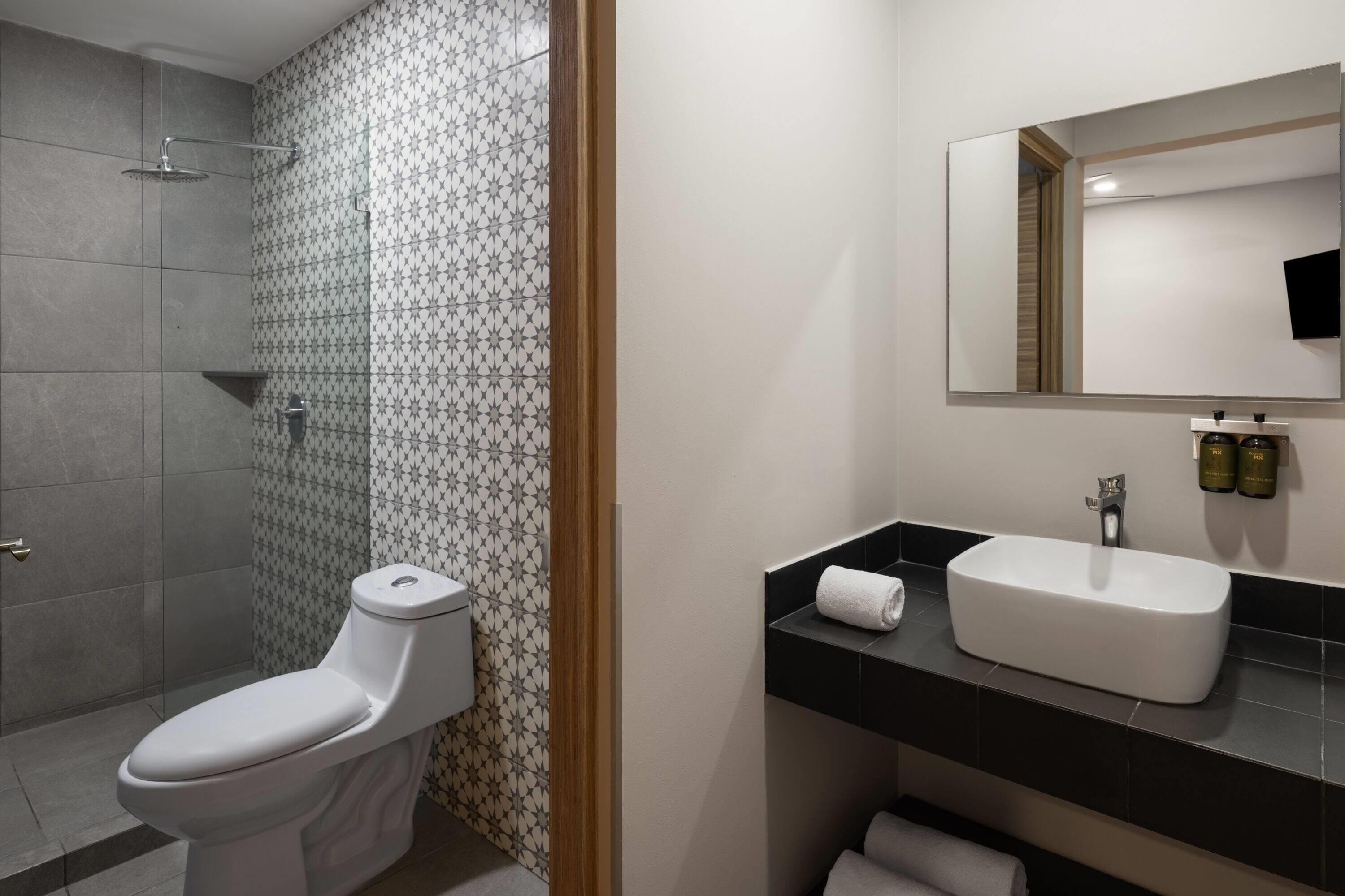 Un baño moderno con inodoro, ducha y lavamanos.
