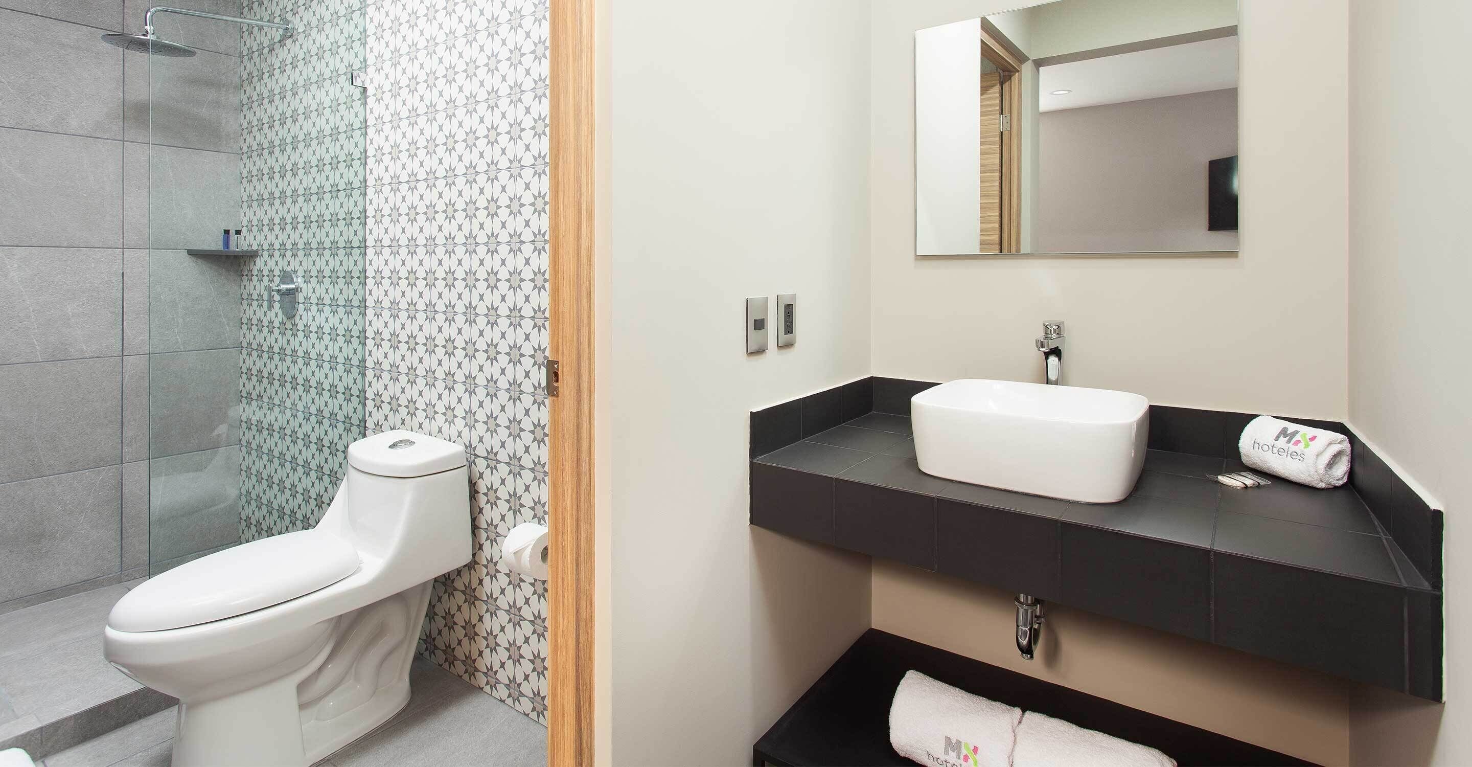 Un baño moderno con inodoro, ducha y lavamanos.