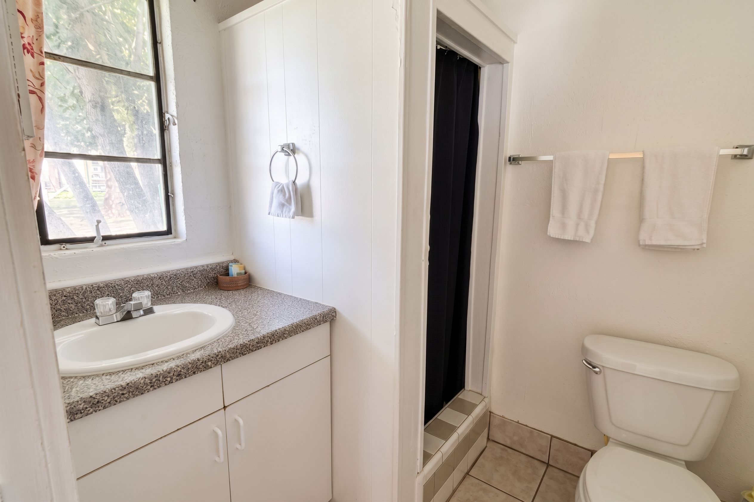 Un baño con lavamanos, inodoro y ventana.