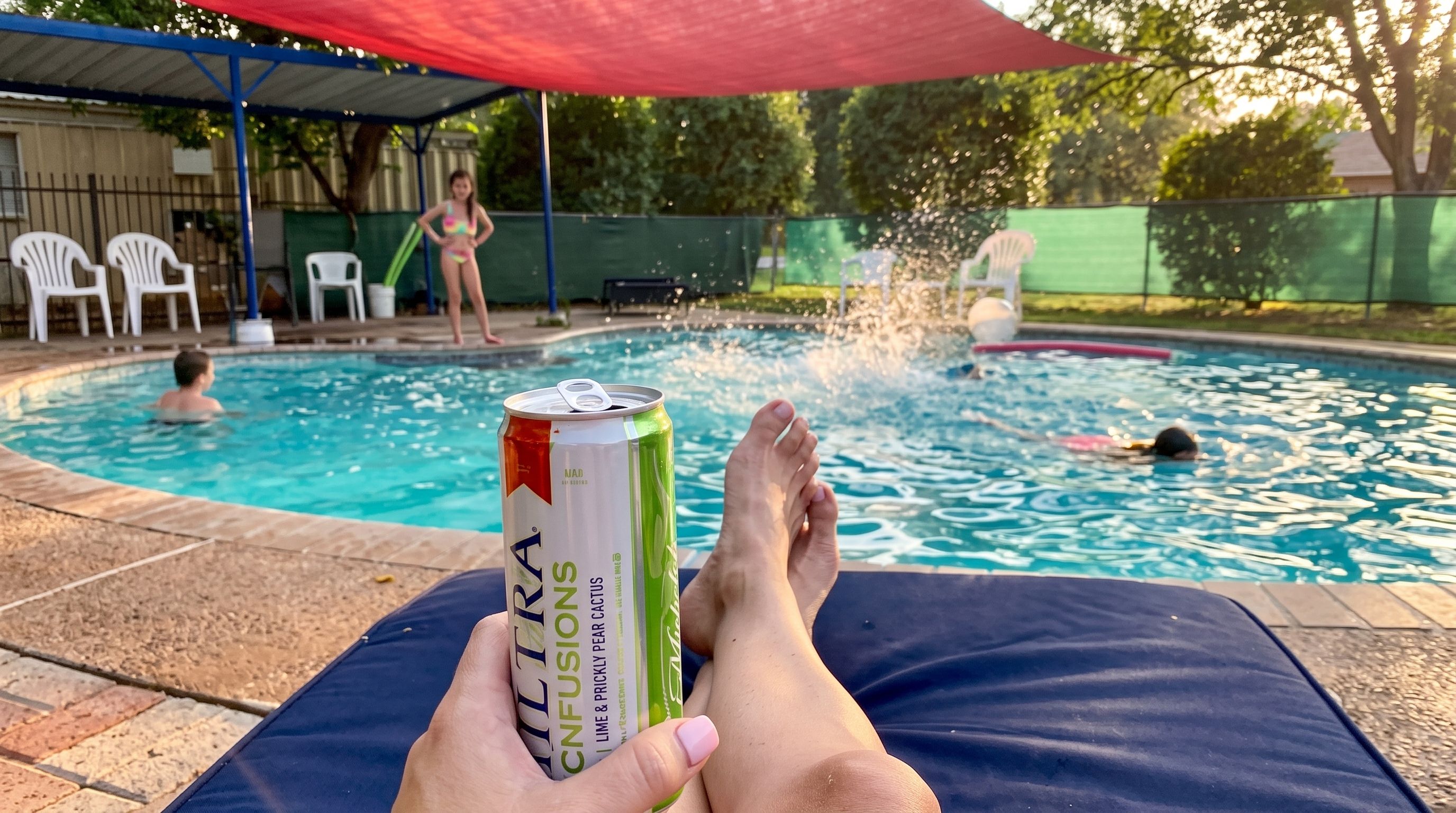 A person relaxing by a pool with a can of drink in hand.