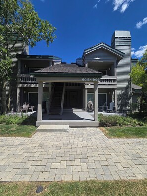 A two-story building with a covered entrance and a staircase leading to the upper level.